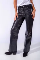 Pantalón de jean negro con apliques de lentejuelas plateadas.