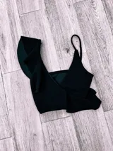 Top de bikini fucsia con un solo tirante y volados en el escote.