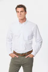 Camisa de vestir celeste con finas rayas verticales blancas, de corte clásico, manga larga y cuello abotonado.