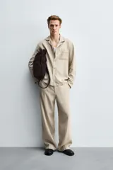 Pantalón de corte relaxed fit confeccionado en una mezcla de lyocell y lino. Presenta bolsillos frontales, bolsillos traseros de vivo y cierre frontal con cremallera y botón.