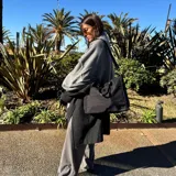 Ruana de material símil cachemira, de diseño bicolor en tonos gris y lila con bandas anchas en los bordes.