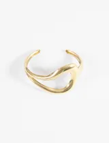 Pulsera rígida abierta de metal dorado, con diseño orgánico y curvo.