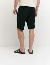 Bermuda chino de corte recto, color verde militar, confeccionada en algodón con elastano. Cuenta con bolsillos laterales de estilo italiano y bolsillos traseros con botón.