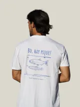Remera blanca de manga corta con estampa en la espalda en color azul que incluye la frase 'Bo, hay pique!' y dibujos de peces y una caña de pescar.