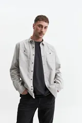 Camisa manga larga color verde oliva, corte slim fit, con cartera abotonada, dos bolsillos frontales con botón y confeccionada en 100% algodón.