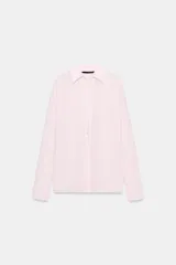 Camisa de corte oversize con cuello solapa y escote en pico. Presenta manga larga con puños abotonados, cierre frontal con botones y detalle de lazada ajustable en la espalda.