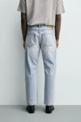 Jeans regular fit de denim de algodón en color gris con efecto lavado, tiro medio, diseño de cinco bolsillos y cierre frontal con botones.