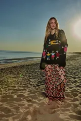 Sweater de lana negro con bordados de figuras humanas multicolores.