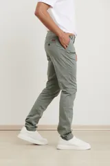 Pantalón de gabardina de corte recto y tiro medio, con bolsillos laterales y traseros, y cierre frontal con botón y cremallera.