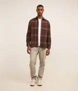 Camisa de franela a cuadros en tonos de azul marino y gris oscuro, con corte regular, manga larga, cuello camisero, cierre frontal de botones y un bolsillo en el pecho.