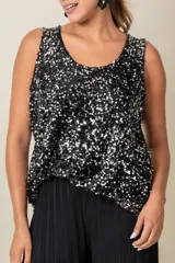 Blusa sin mangas confeccionada en tela cubierta de lentejuelas doradas y plateadas, con escote redondo y corte holgado.