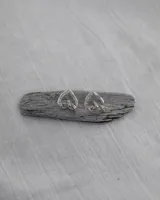 Aros de diseño minimalista en forma de corazón irregular, con acabado metálico pulido y cierre de perno con mariposa.