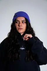 Canguro negro con capucha, cierre frontal parcial y bolsillo tipo canguro. Presenta un estampado gráfico pequeño en el centro del pecho.