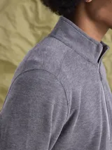 Buzo tipo fleece con cierre medio frontal y cuello alto, confeccionado en tejido de algodón. Presenta un diseño de calce cómodo y versátil.