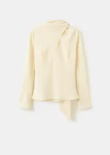 Blusa de manga larga en color crema, confeccionada en poliéster. Presenta un diseño de cuello alto con un sutil detalle de abertura frontal y corte recto.