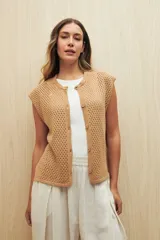 Chaleco tejido calado color blanco, sin mangas, con botones al frente y diseño abierto.