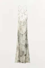 Vestido midi de viscosa con estampado floral y geométrico en tonos neutros. Presenta escote redondo, tirantes finos cruzados en la espalda con ajuste de lazada y forro interior.