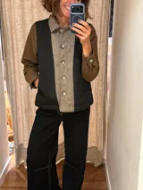Campera de diseño híbrido con frente acolchado en color tostado, solapas y cuello en tejido de lana con patrón de cuadros tipo príncipe de gales, y mangas en paño de lana color azul marino. Cuenta con cierre frontal de botones.