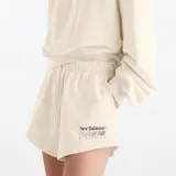 Short New Balance de felpa francesa color beige, con cintura elástica y cordón de ajuste. Cuenta con bolsillos laterales y detalle de bordado y estampado con el logo de la marca en el muslo izquierdo.