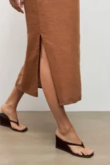 Vestido midi de lino color blanco, de corte recto y holgado, con escote cuadrado y tirantes finos.