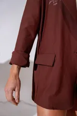Blazer sastre color marrón, de corte holgado y diseño minimalista, con solapas clásicas y cierre frontal de un botón.