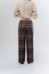 Pantalón de corte recto con estampado a cuadros en tonos marrones y rosados. Presenta una pretina elástica para mayor comodidad y está confeccionado en una tela acanalada con caída suave.