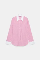 Camisa de rayas rosas y negras, con cuello solapa y puños anchos en color blanco. Presenta mangas largas, bajo asimétrico y cierre frontal con botones.