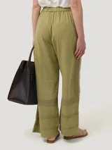 Pantalón de tiro alto con corte recto, confeccionado en mezcla de lino y viscosa. Presenta un diseño sofisticado con ajuste lateral mediante hebillas metálicas y bolsillos laterales.