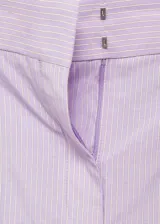 Pantalón wide leg de tiro medio con diseño de rayas verticales finas en color lila. Presenta bolsillos laterales, bolsillos traseros de ribete, trabillas para cinturón y cierre frontal oculto con botón, gancho y cremallera.