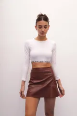 Crop top blanco de algodón con lycra, cuello redondo, manga larga y cintura con elástico afelpado con la inscripción 'RENÉE'.