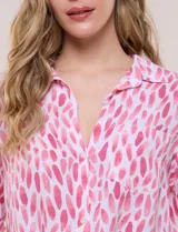 Camisa de lino sintético con estampado floral en tonos azules y beige sobre fondo blanco, de corte holgado, mangas tres cuartos y cuello camisero.