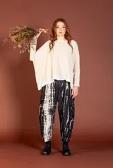 Pantalón de silueta amplia, color negro con estampado tie-dye en blanco, corte holgado y tobillos ajustados.