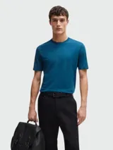 Remera de algodón de corte regular, color gris oscuro, con cuello redondo y logo de la marca bordado discretamente en el pecho.
