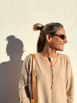 Buzo de tejido de punto color beige, de corte holgado y mangas largas.