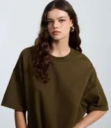 Remera oversize blanca de manga corta, con cuello redondo y diseño holgado, confeccionada en mezcla de algodón y poliéster.