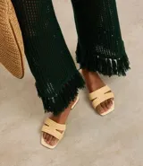 Sandalias planas color beige con puntera cuadrada y tiras anchas con efecto rafia.