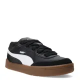 Championes Puma modelo Park Life Style SK8, de corte bajo en color negro con detalles en blanco y suela de goma color caramelo. Presentan un diseño urbano inspirado en el skate con cordones gruesos y refuerzos en la puntera.