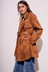 Trench marrón de gamuza vegana con cuello solapa, manga larga, cinturón con hebilla y corte evasé.