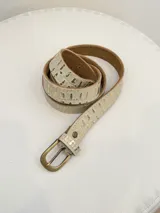 Cinto de cuero con textura de cocodrilo en tono beige con detalles dorados, hebilla metálica en color bronce envejecido.
