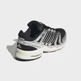 Championes Adidas Adistar Control 5 de running, con diseño retro de los años 2000. Combinan base de malla negra con superposiciones metálicas plateadas y entresuela en tono blanquecino.