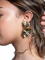 Aros grandes de metal dorado con diseño orgánico y acabado brillante, inspirados en hojas.