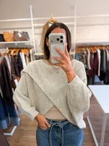 Capa tejida de punto en color verde oliva, con diseño cruzado en el frente y mangas tipo murciélago de calce holgado.