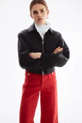 Jean rojo de tiro alto, corte wide leg y diseño tobillero, con bolsillos delanteros tipo parche con botón y pliegues marcados.