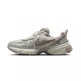 Championes Nike V2K Run de estilo retro-futurista, con diseño en capas de malla y material sintético en tonos beige y gris. Presenta una entresuela robusta con tecnología Cushlon y el logo de Nike en el lateral.