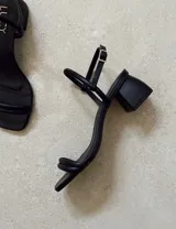 Sandalias de tacón bajo color blanco, con tiras finas y cierre con hebilla.