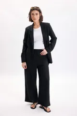 Blazer sastrero de lino color negro, con solapas clásicas, bolsillos delanteros con solapa y diseño de corte recto.