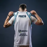 Camiseta de básquet Umbro de Uruguay, modelo alternativo. Diseño blanco con detalles celestes y el logo de Antel en el frente.