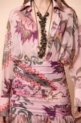 Camisa de manga larga fluida con estampado floral estilo paisley en tonos rosas, verdes y violetas, con cuello camisero y escote en V profundo.