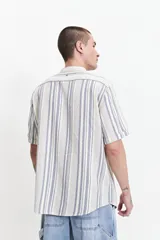 Camisa de manga corta con cuello mao y diseño a rayas verticales en tonos azules y crudo. Confeccionada en tejido de algodón con textura y corte slim fit.