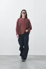 Camisa de manga larga en color celeste, con cuello mao y cierre frontal oculto. Presenta un diseño de silueta relajada con sisa caída y un bolsillo aplicado en el pecho.
